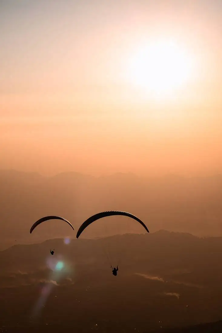 Paraglider flying over the hills around Bir Billing